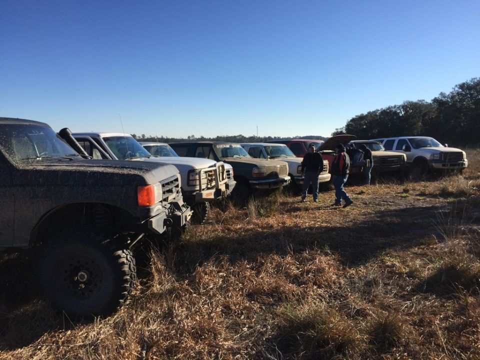 Several trucks parked in a field, one in foreground