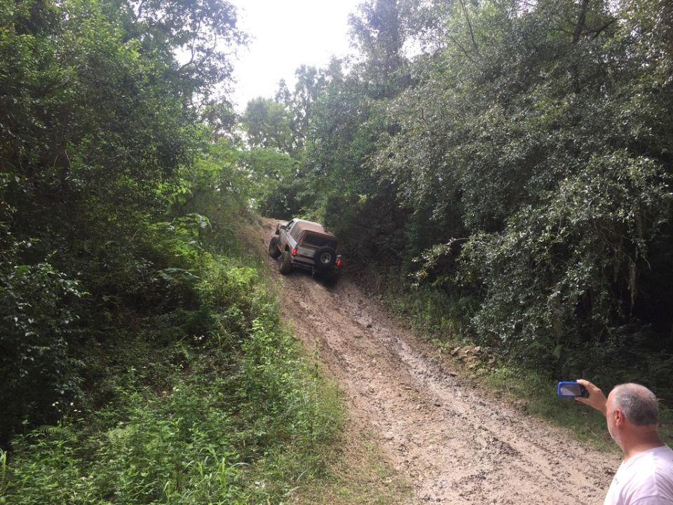 1989 Ford Bronco climbing a muddy hill, rear view