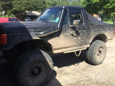 1989 Ford Bronco - Muddy 1989 Ford Bronco with off-road modifications, parked outdoors.