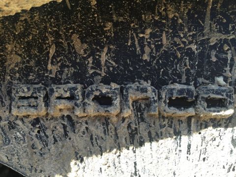 1989 Ford Bronco - Mud covers the tire tread, obscuring the vehicle it belongs to, but the word BRONCO is still legible.