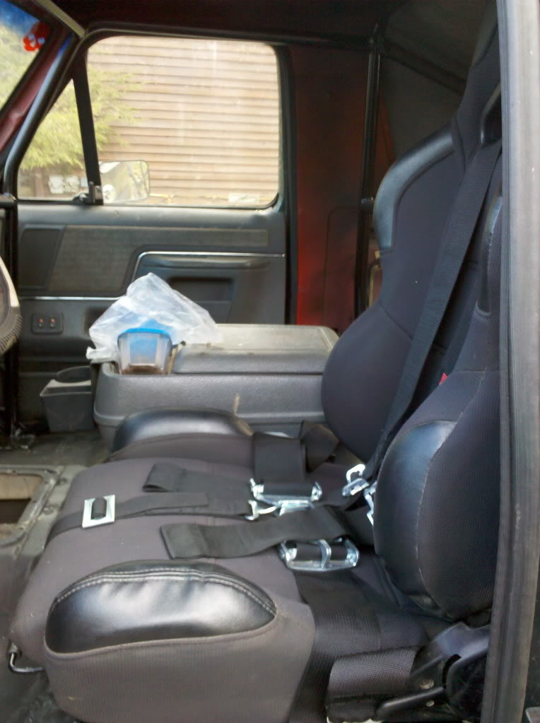 Interior view of racing seats and center console with a plastic container on top