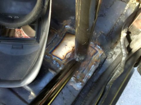 1989 Ford Bronco - Underside/floor pan area showing rust, weld repairs and seat-mount studs through the cab floor.