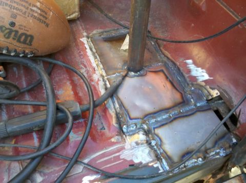 1989 Ford Bronco - The interior floor pan shows evidence of welding repairs, with a football and cables present.