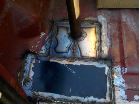 1989 Ford Bronco - Close-up of a welded patch on the floor of a vehicle, likely a repair.