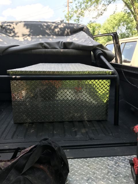 1989 Ford Bronco - A diamond plate toolbox sits in the bed of a truck, with another vehicle partially visible in the background.