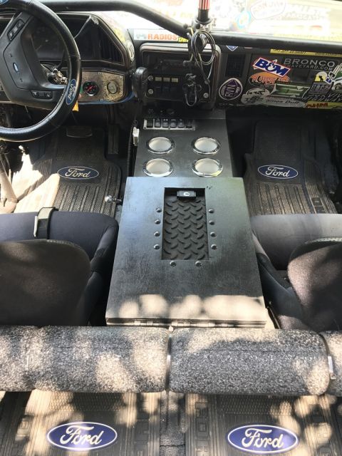 1989 Ford Bronco - The interior of a 1989 Ford Bronco shows custom modifications and Ford branding on the floor mats.