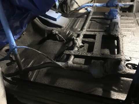 1989 Ford Bronco - The interior floor of a vehicle is shown with protective coverings and structural elements visible.