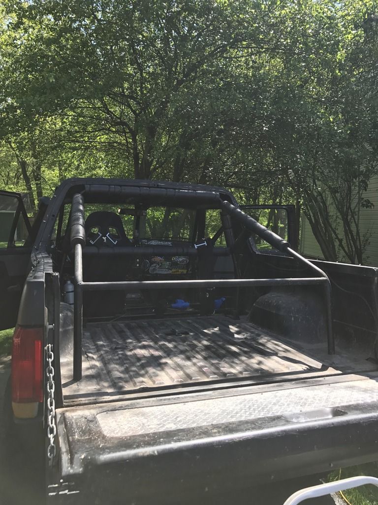 Pickup truck bed with black tubular roll bar and chase rack