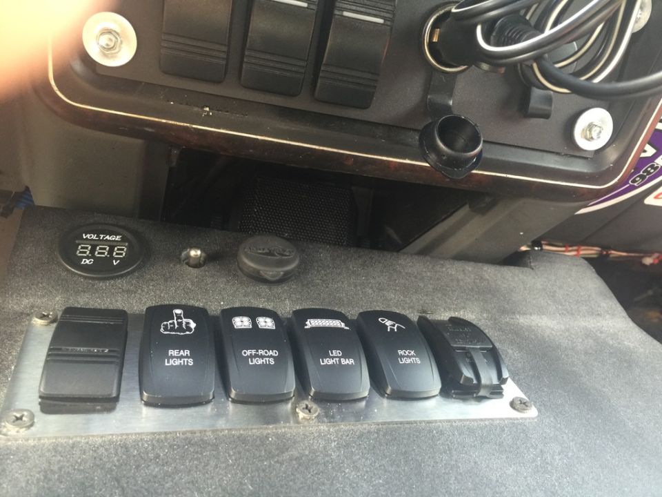 Interior dashboard with switches for rear lights, off-road lights, LED light bar, and rock lights