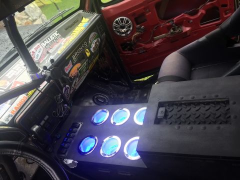 1989 Ford Bronco - The interior of a vehicle features a custom dashboard with multiple blue-lit gauges and a variety of stickers, including one that says 'Bro…