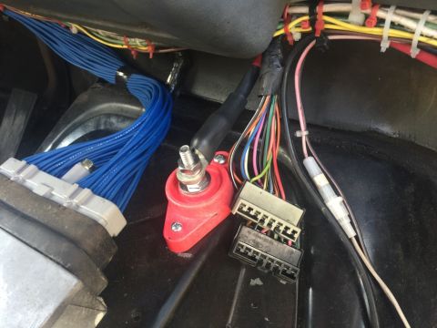 1989 Ford Bronco - Close-up view of a vehicle's complex wiring harness, showing multiple connectors and a battery terminal.