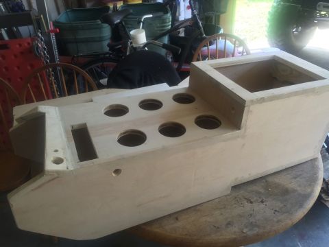 1989 Ford Bronco - A custom wooden console, possibly for a vehicle, is shown unfinished with several circular openings.