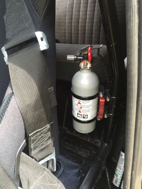 1989 Ford Bronco - Interior view showing a fire extinguisher and seatbelt, likely in an older vehicle.