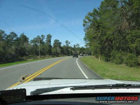 1989 Ford Bronco - A view from inside a vehicle driving on a highway with other cars on the road.
