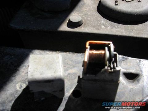 1989 Ford Bronco - An automotive relay with visible copper windings is shown in this close-up view.