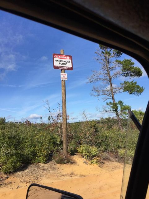 1989 Ford Bronco - A sign warns of unexploded bombs in a remote, wooded area.