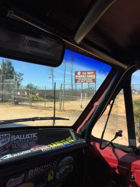 1989 Ford Bronco - Interior view of a vehicle parked near a U.S. Navy Bombing Range, with numerous stickers on the dashboard.