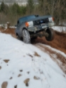 1989 Ford Bronco - This SUV navigates a challenging off-road course with snow and mud, demonstrating its all-terrain capabilities.