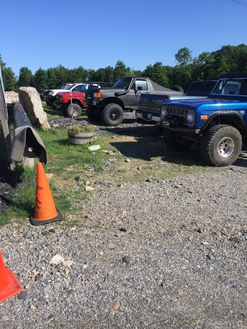 1989 Ford Bronco - A blue 1978 Ford Bronco with a winch is parked in a lot with other off-road vehicles.