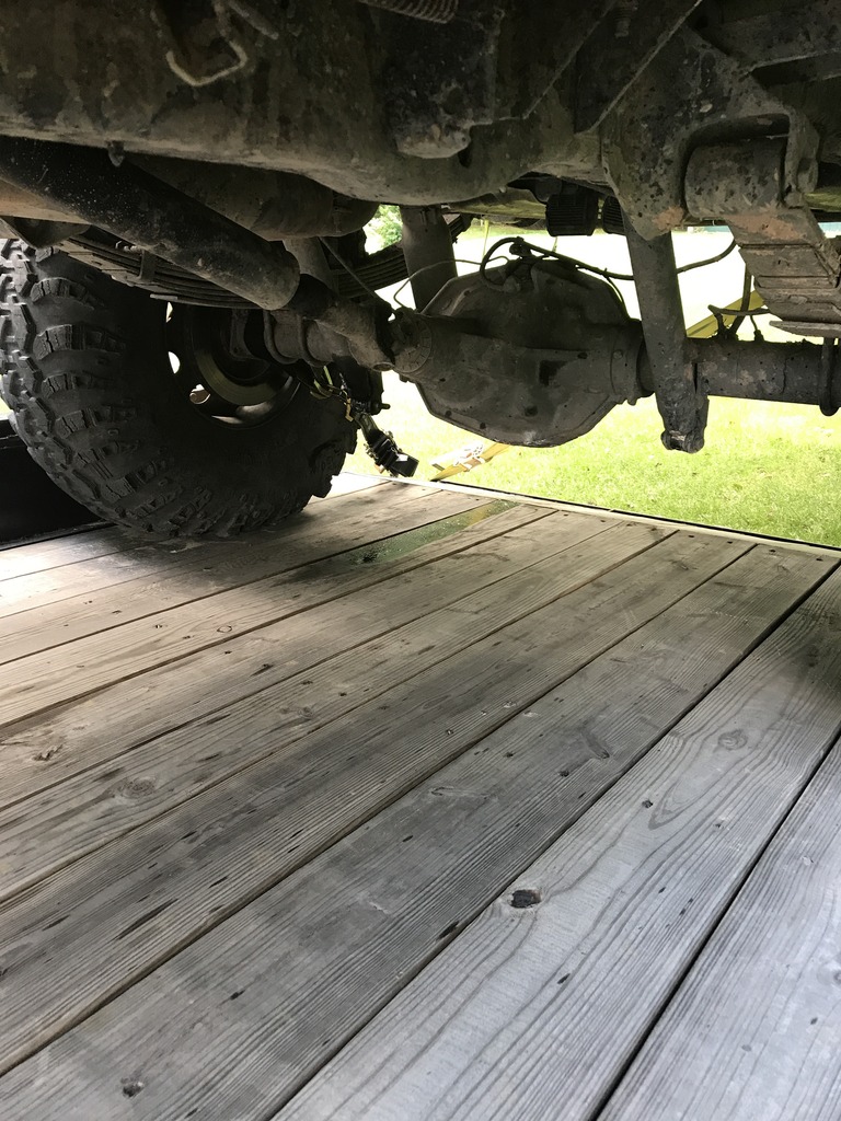 Undercarriage view of a vehicle's rear axle and tire