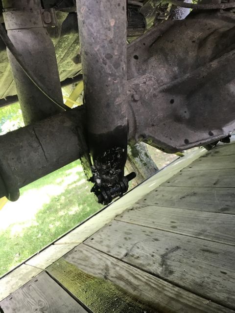 1989 Ford Bronco - Underside view of a vehicle's rear axle and driveshaft, showing grease and wear.
