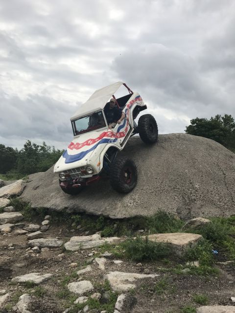 1989 Ford Bronco - This modified Ford Bronco is navigating a challenging rock obstacle on an off-road course.