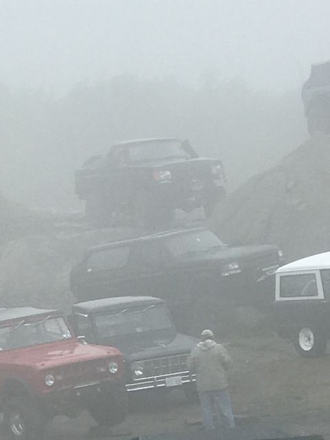 1989 Ford Bronco - Several off-road vehicles, including a 1989 Ford Bronco, navigate a foggy terrain.