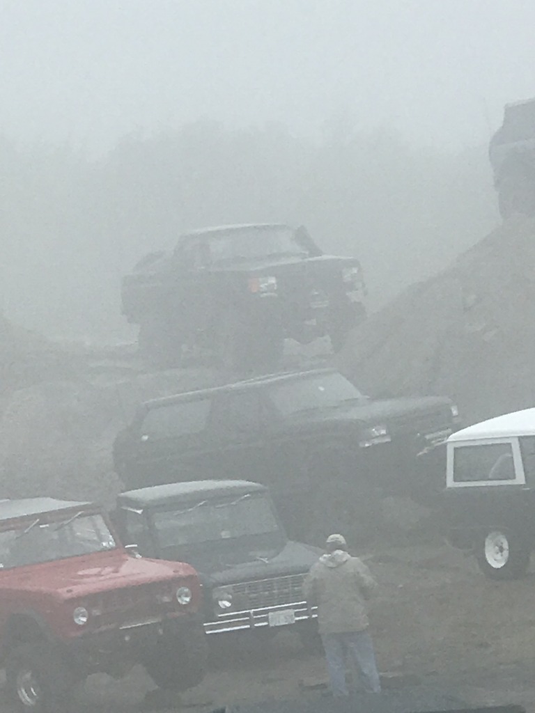 1989 Ford Bronco front view in fog with other off-road vehicles