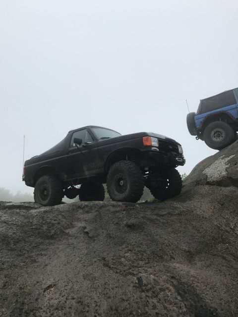 1989 Ford Bronco - Two Ford Broncos navigating a challenging rocky off-road course.