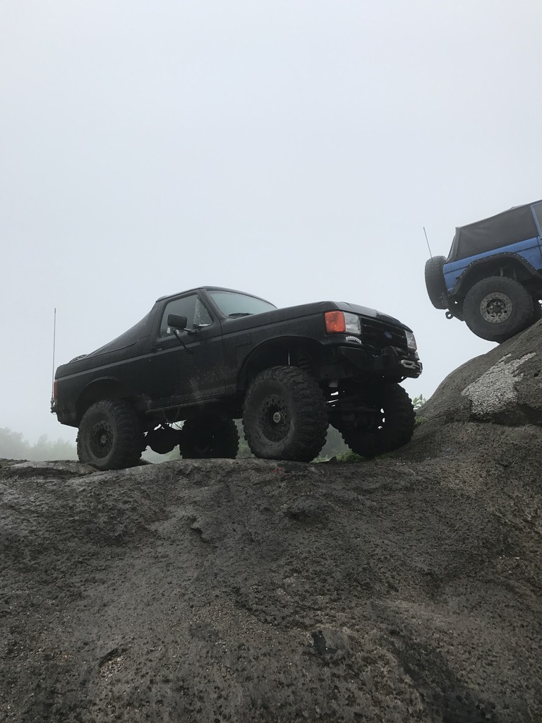 1989 Ford Bronco climbing rocks, another Bronco behind it