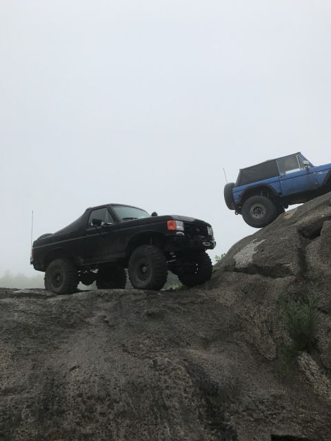 1989 Ford Bronco - Two Broncos navigate a rocky trail on a foggy day.