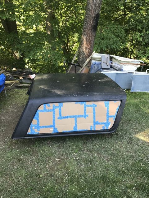 1989 Ford Bronco - A black hardtop is shown outdoors, with its window covered by blue tape and cardboard.
