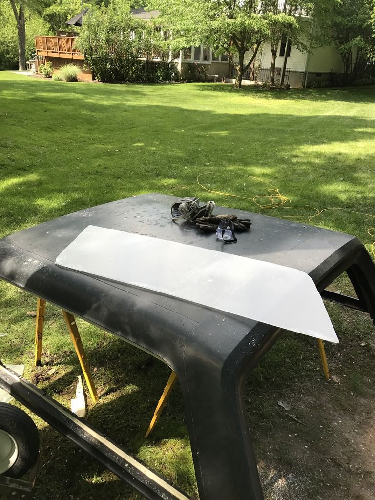 Black hardtop on sawhorses with a metal panel and tools
