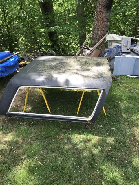 1989 Ford Bronco - Hardtop for a 1989 Ford Bronco sits on yellow sawhorses in a grassy yard.