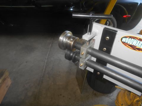 1992 Ford Bronco - A Woodward sheet metal roller is shown in close-up, with a dark-colored vehicle partially visible in the background.