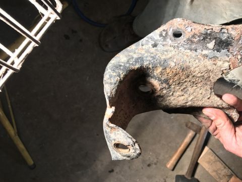 1989 Ford Bronco - A close-up of a corroded metal part, likely from a vehicle's suspension system.