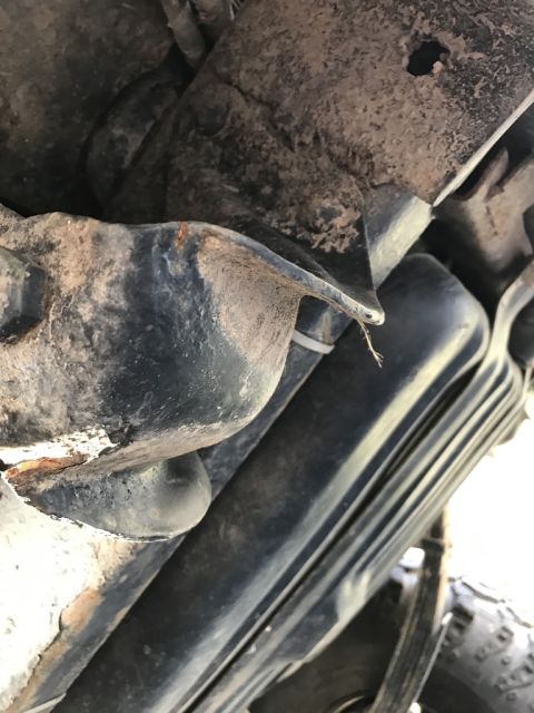 1989 Ford Bronco - Close-up of a dirty and rusty suspension part, possibly from a vehicle's leaf spring area.