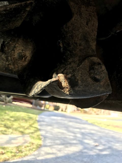 1989 Ford Bronco - Underside view of a corroded vehicle part, possibly a leaf spring shackle.