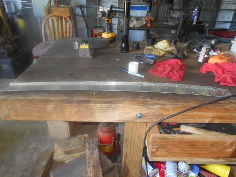 1992 Ford Bronco - A workbench is cluttered with tools and a long metal strip, suggesting a work-in-progress.