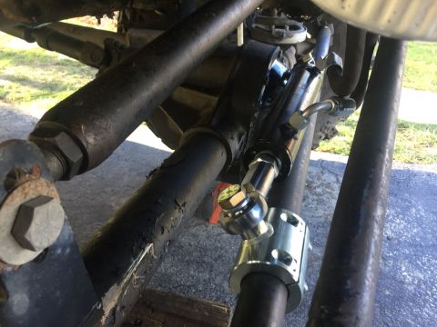 1989 Ford Bronco - Close-up view of a steering stabilizer shock absorber installed on a vehicle's linkage system.