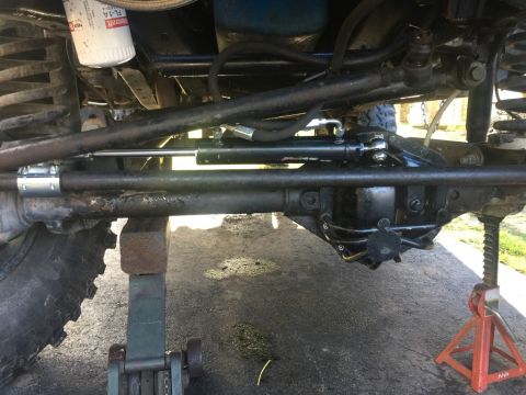 1989 Ford Bronco - Close-up view of the steering and suspension system of a 1989 Ford Bronco, elevated on jacks for service.
