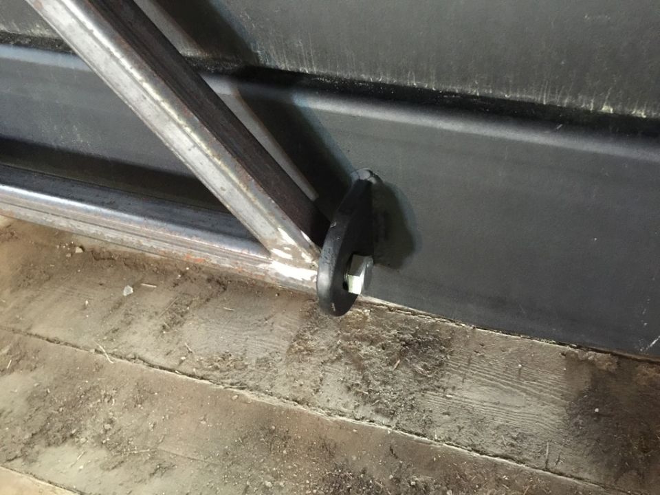 Close-up of a metal bracket attached to a dark surface with a bolt.