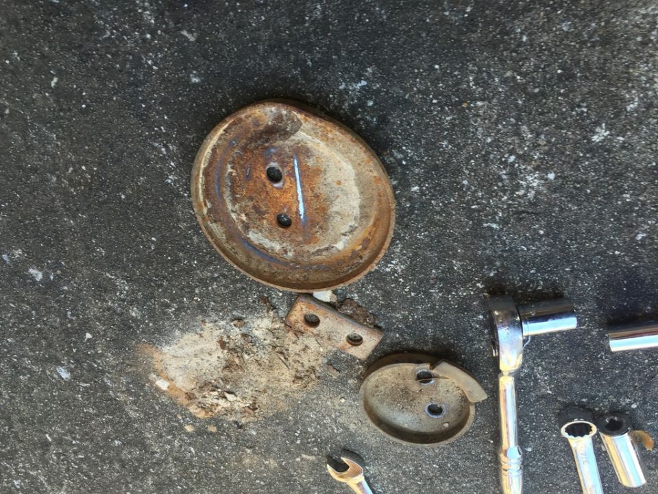 Rusty metal parts and tools on a concrete surface.