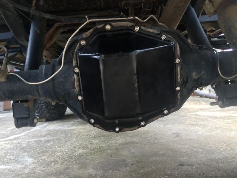 1989 Ford Bronco - The rear differential of a 1989 Ford Bronco with a black aftermarket differential cover installed. The cover is secured with multiple bolts…