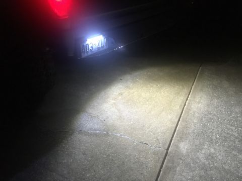 1989 Ford Bronco - The rear of a vehicle at night, showing a license plate illuminated by bright white lights. The license plate reads "403-ZLV".