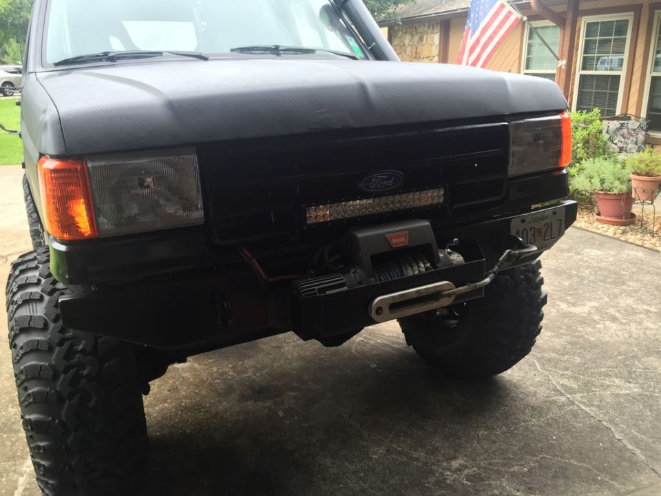 Black 1989 Ford Bronco front view with winch and LED light bar.