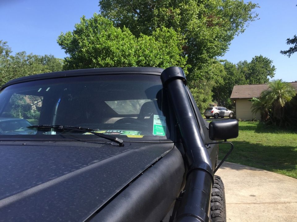 Black SUV with snorkel intake parked on driveway.