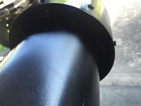 1989 Ford Bronco - A close-up, low-angle shot shows a textured, matte black exhaust pipe and muffler assembly. The metallic surface has a slightly rough finis…