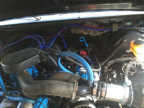1989 Ford Bronco - Close-up view of an engine bay, highlighting custom snorkel installation with blue tubing.