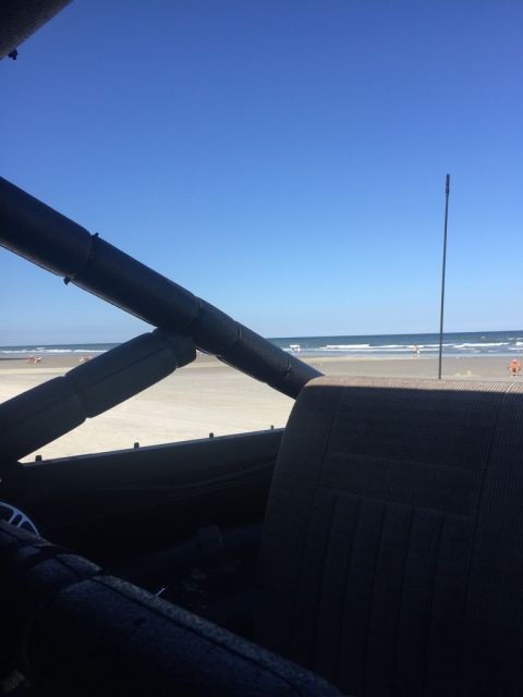 1989 Ford Bronco - Looking out from the interior of a vehicle towards a beach scene on a sunny day.